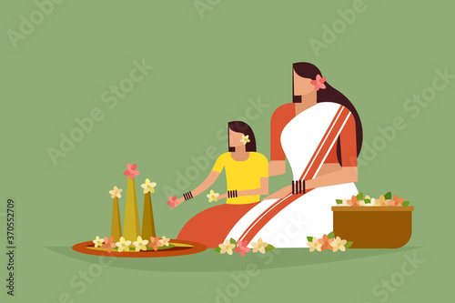 Traditionally dressed mother and daughter do floral designs on floor. Concept of Onam festival in Kerala. photo