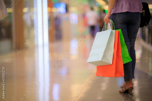 Women carrying a lot of colorful shopping bags in blurred shopping mall © sutthichai