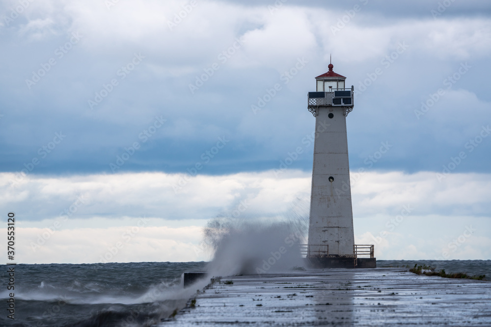 Sodus Bay Lighthouse during a storm just after dawn on a summer day.