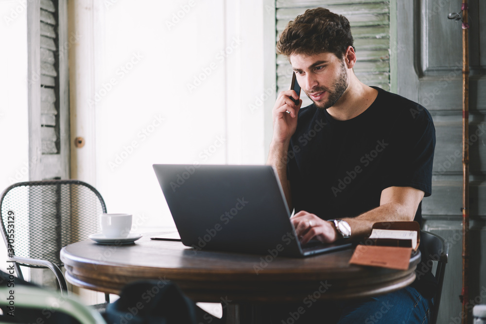 Talented manager working freelance in building industry attracting new customers in startup company via phone callings and using modern laptop with wireless internet connection to increase profits