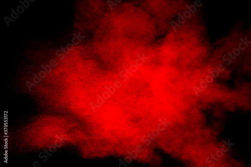 Red powder explosion on black background. Freeze motion of red dust particles splash.