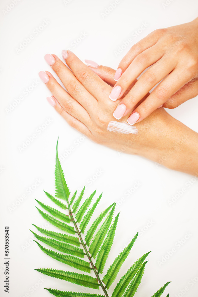 Closeup of beautiful female hand applying hand cream