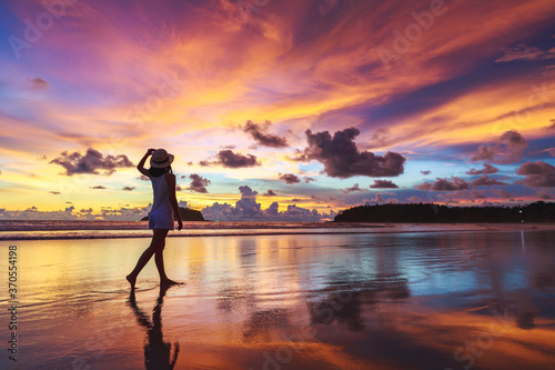 Traveler asian woman travel on Phuket beach in sunset Thailand