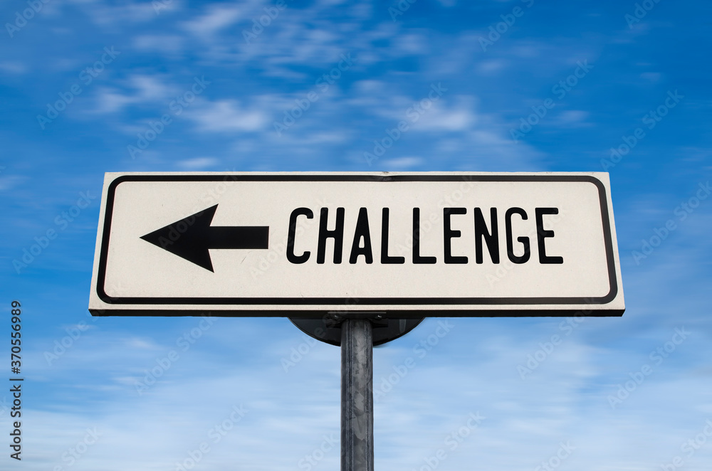 Challenge road sign, arrow on blue sky background. One way blank road sign with copy space. Arrow on a pole pointing in one direction. Challenge road sign, arrow on blue sky background. One way blank road sign with copy space. Arrow on a pole pointing in one direction.
