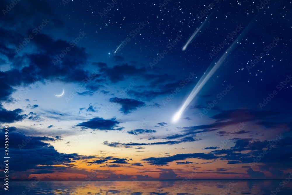 Amazing heavenly image with beautiful glowing sunset, comet and shooting stars, rising crescent moon and bright stars above sea.