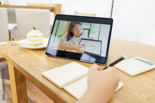 Asian woman aged 30-35 years using tablet, watching lesson online course communicate by conference video call from home, e-learning education concept