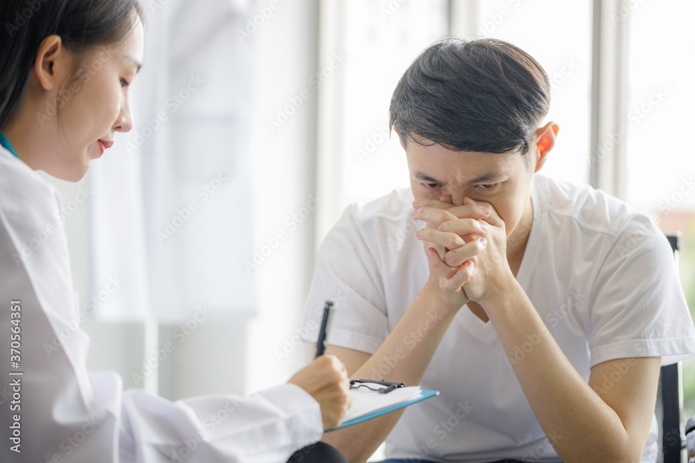 Beautiful young Asian female doctor is recording a medical history on the clipboard and explaining something to the male patient. Medical and health care concepts Beautiful young Asian female doctor is recording a medical history on the clipboard and explaining something to the male patient. Medical and health care concepts
