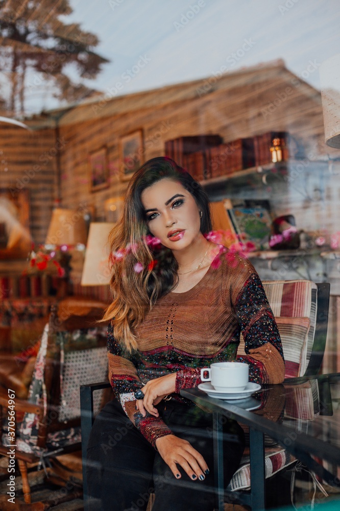 Beautiful model posing for photos in a room. Wearing black pants and brown blouse. Beautiful model posing for photos in a room. Wearing black pants and brown blouse.