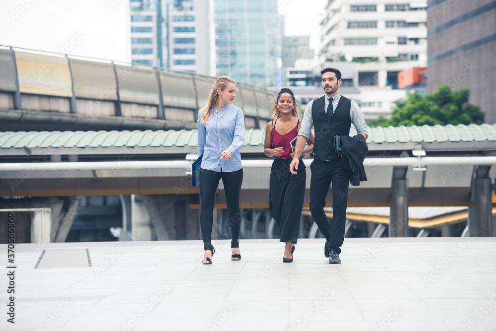 Group of business people walking talking. Three Business people walking outside office Group of business people walking talking. Three Business people walking outside office
