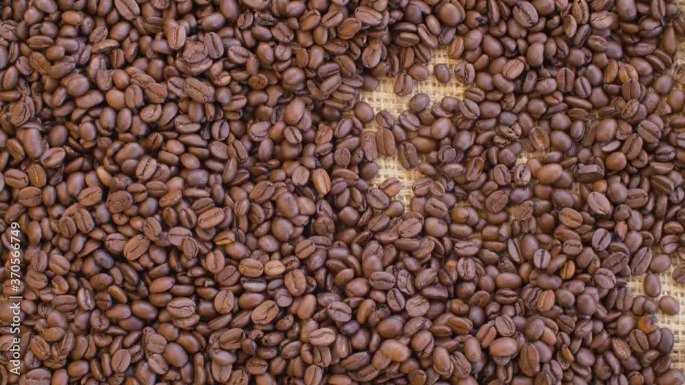 Close up roasted coffee beans on burlap. Raw fresh food concept. Camera slowly moving on slider, dolly shot, top view. Texture, background Close up roasted coffee beans on burlap. Raw fresh food concept. Camera slowly moving on slider, dolly shot, top view. Texture, background