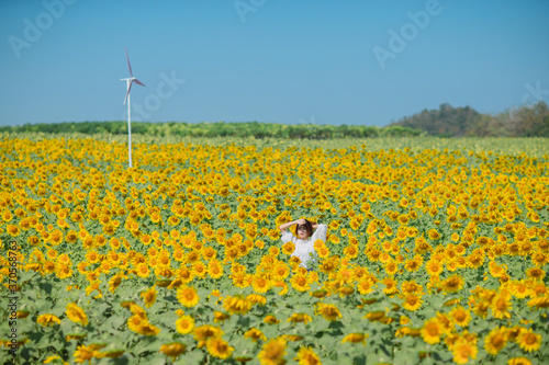 Beautiful smile asian young woman in sunflower field. Happy girl in sunflower field. Portrait of asian woman in sunflower field when traveling on vacation.