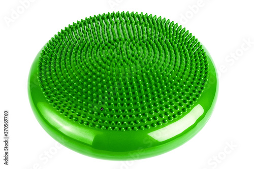 Green inflatable balance disk isoleated on white background, It is also known as a stability disc, wobble disc, and balance cushion.