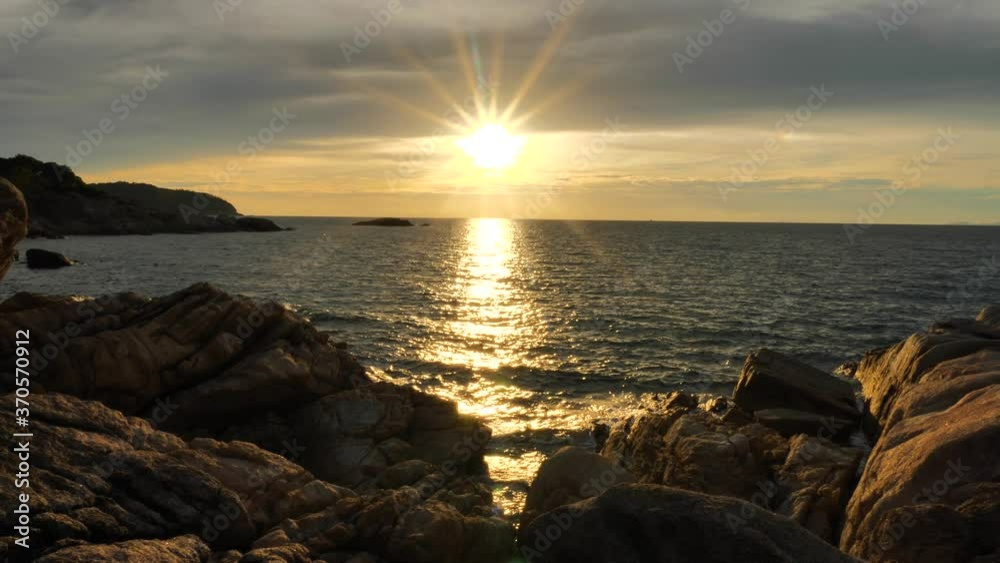 Amazing Sun Rays at Sunset time above the ocean, water surface at rocky coast in slow motion at sunset time, nature background static shot Amazing Sun Rays at Sunset time above the ocean, water surface at rocky coast in slow motion at sunset time, nature background static shot