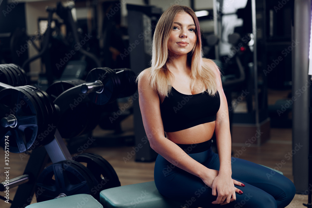 Fototapeta premium Portrait of a fit young blonde woman in black sport bra