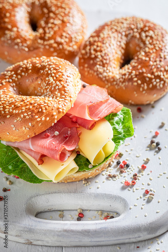 Tasty bagel with prosciutto and cheese for quick lunch