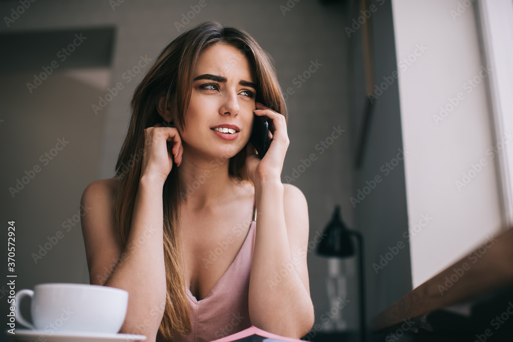 Young worried woman talking on phone at home Young worried woman talking on phone at home
