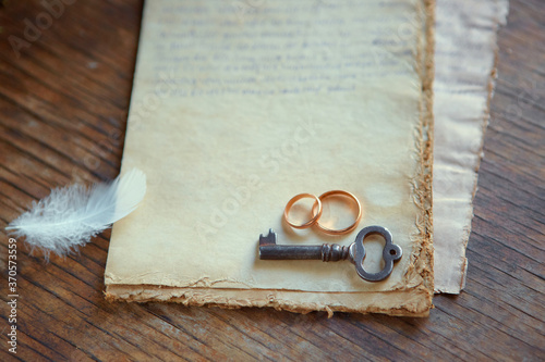 Wedding rings, an old key, a feather-are on old vintage paper. Symbols of eternal love. Recognition on Valentine's day