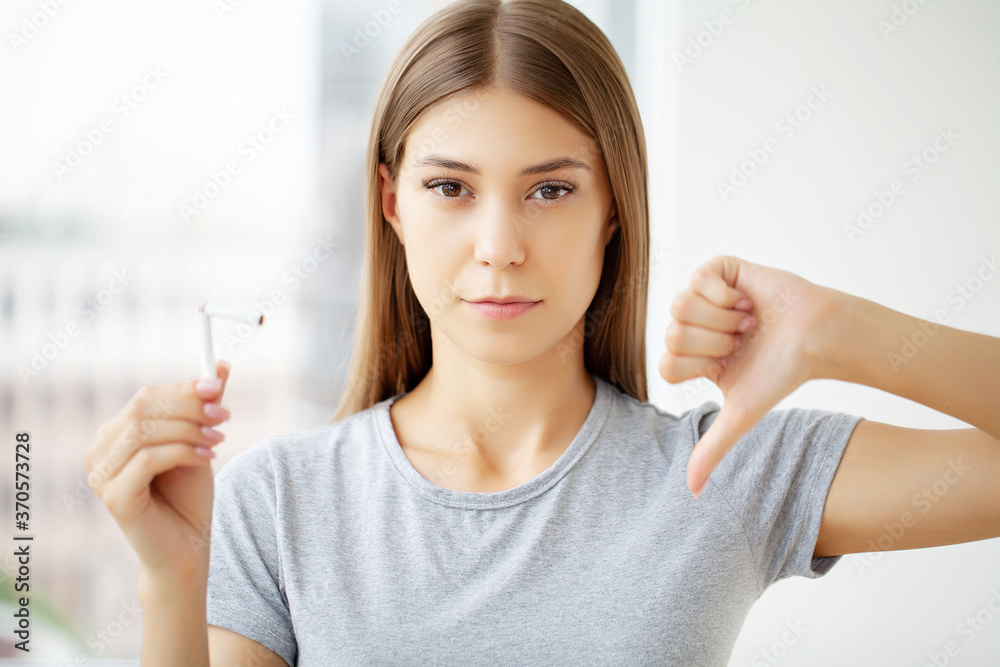 Stop smoking, a young woman holding a broken cigarette Stop smoking, a young woman holding a broken cigarette