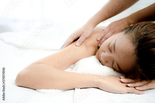 Beautiful woman lying face down She was relaxed as the massage therapist kneaded her shoulders. Spa massage concept.