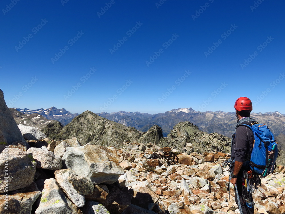 Alpiniste qui grimpe avec corde et casque en escalade sur les arêtes Ferbos du Néouvielle et des trois conseillers montagne dans le Parc National des Pyrénées en France du Languedoc