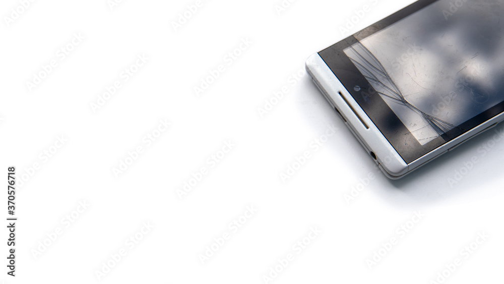 Smartphone with broken glass in right top corner of the picture isolated on white background. Damaged screen of modern mobile phone. Copy space photo Smartphone with broken glass in right top corner of the picture isolated on white background. Damaged screen of modern mobile phone. Copy space photo