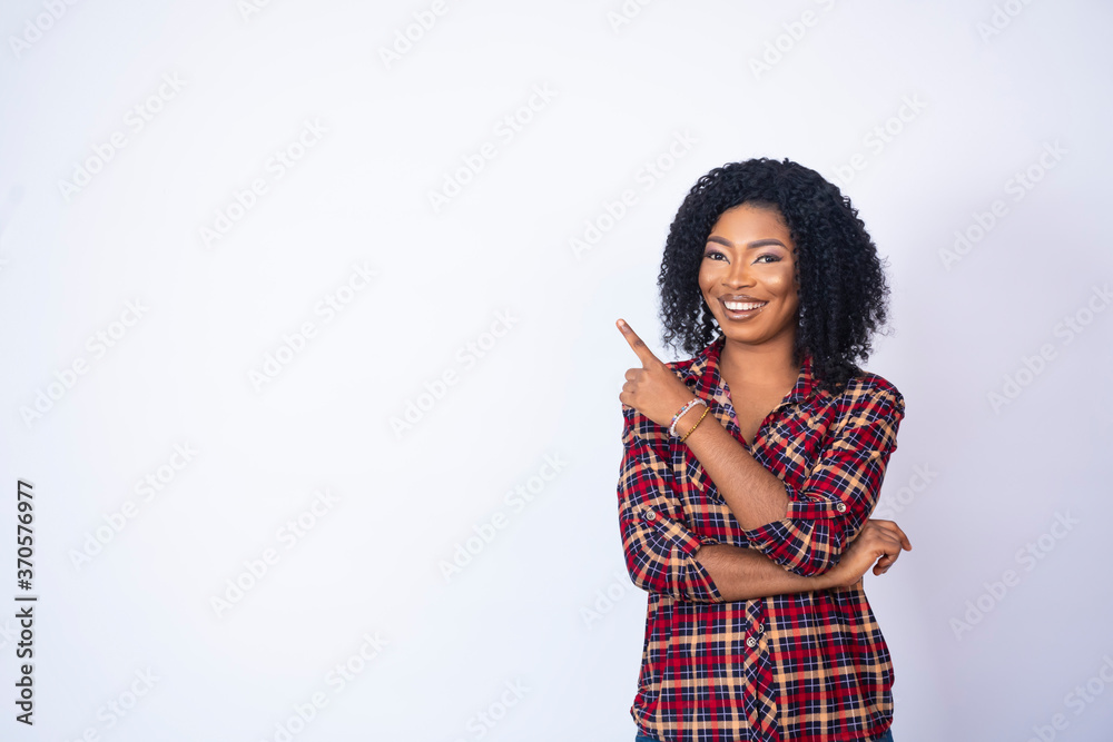 pretty black woman smiling and pointing to the space on her side pretty black woman smiling and pointing to the space on her side