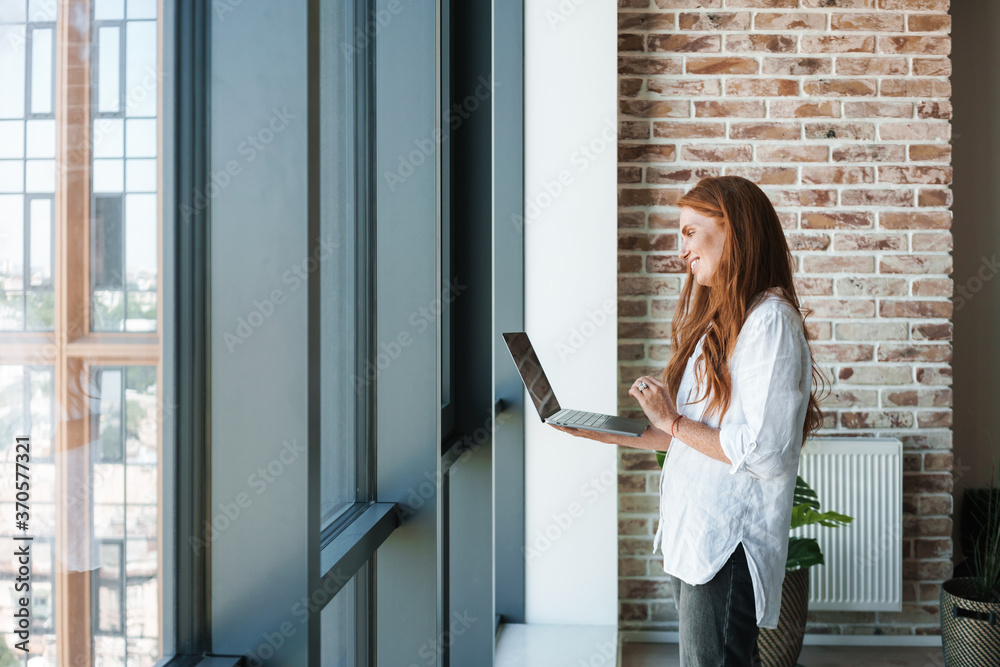 Image of redhead businesswoman making video call on laptop Image of redhead businesswoman making video call on laptop