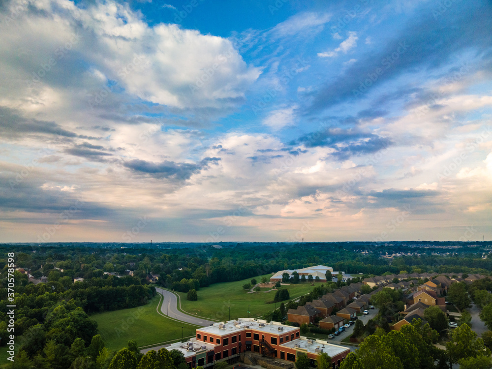 A view towards neighborhoods and a park in Lexington, KY USA with colorful clouds on the sky