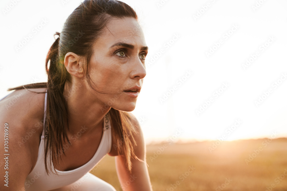 Image of adult beautiful sportswoman looking aside while working out Image of adult beautiful sportswoman looking aside while working out