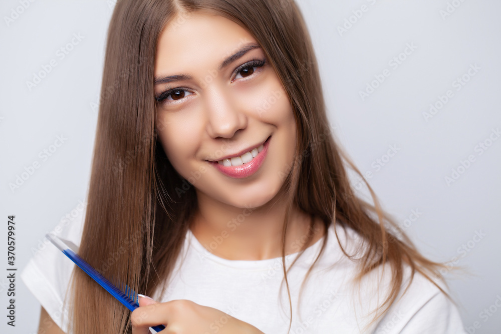 Young beautiful woman combing her hair in living room Young beautiful woman combing her hair in living room