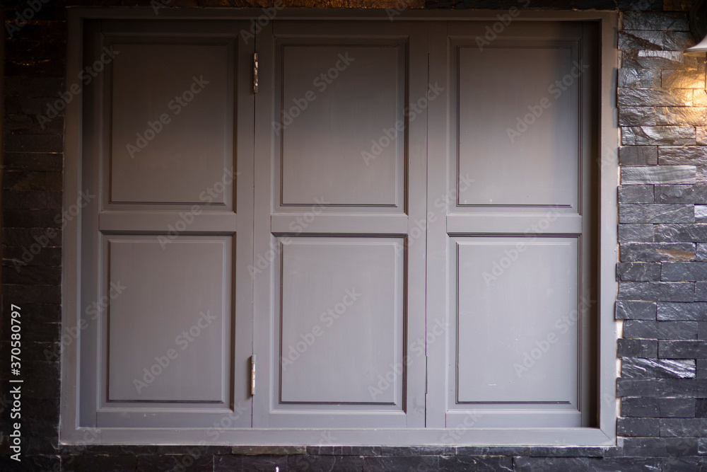 Gray wooden closed windows on wall background texture