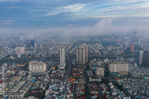 Aerial view of early morning fog in built-up urban area with high rise buildings and background obscured by low cloud