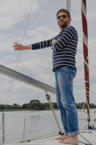 Man with beard drinking whiskey on yacht