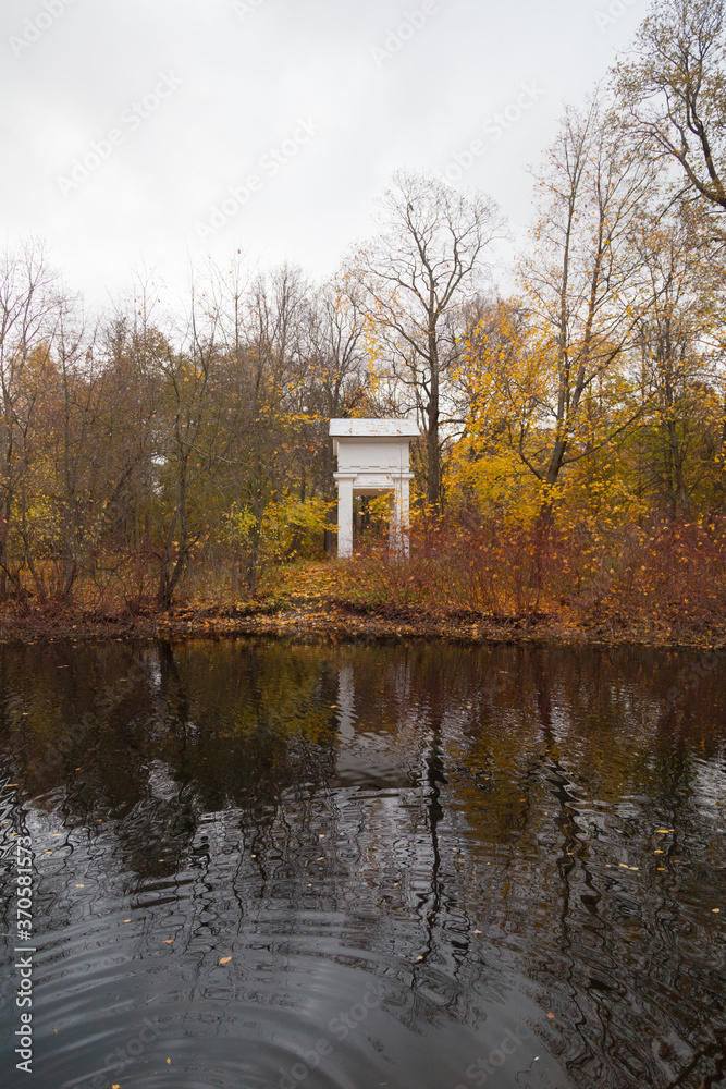 White arch among autumn trees reflected in a pond White arch among autumn trees reflected in a pond