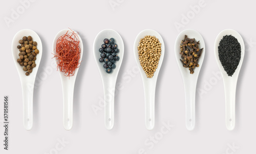 Peppers and powders with Herbs and spices on spoons on a white background