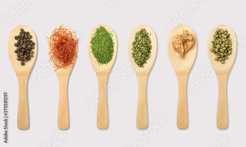 Herbs and spices on spoons on a white background
