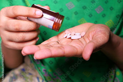 Close up of women hand taking pills 