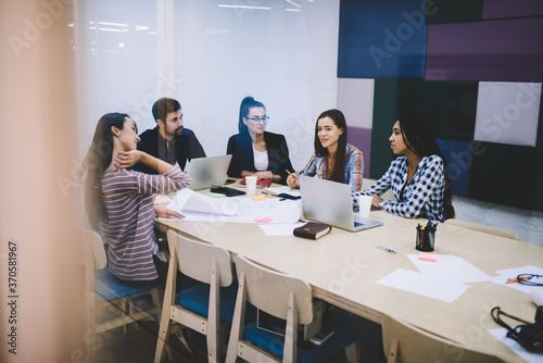 Young crew of talented employee explaining ideas during working meeting with male executive manager.Diversity group of experienced designers sharing creativity during collaboration on conference