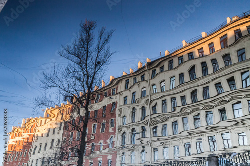 river Reflection of vintage houses and trees without leaves