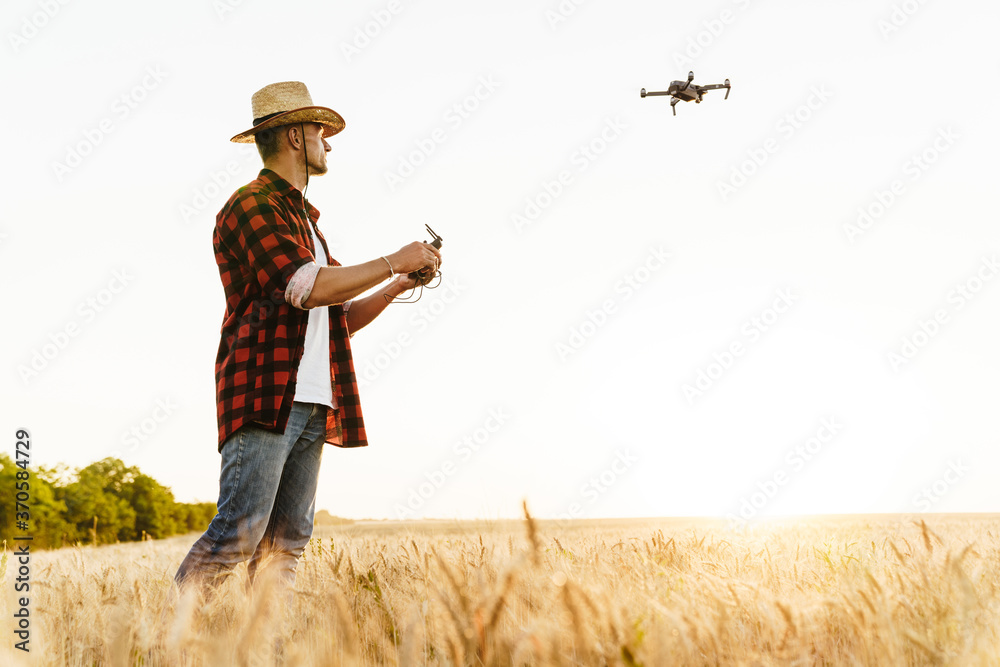 custom made wallpaper toronto digitalImage of focused handsome man using drone while standing at cereal field