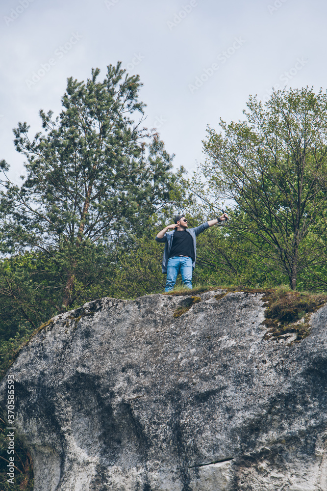 young hiker man on the top of the cliff
