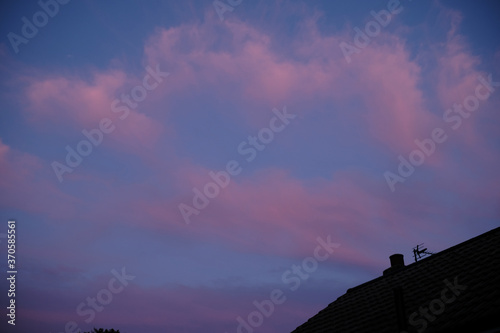 Moody sunset with rooftop tv antenna and blue purple sky