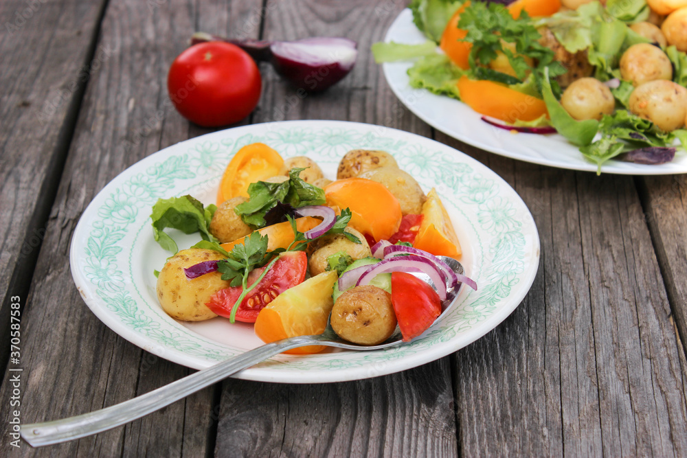 Round new potatoes fried to Golden brown with tomatoes, herbs and lettuce