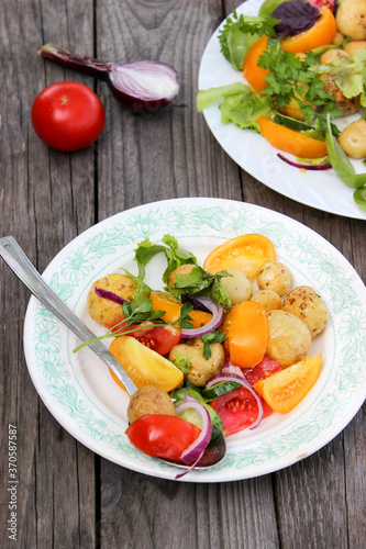 Round new potatoes fried to Golden brown with tomatoes, herbs and lettuce