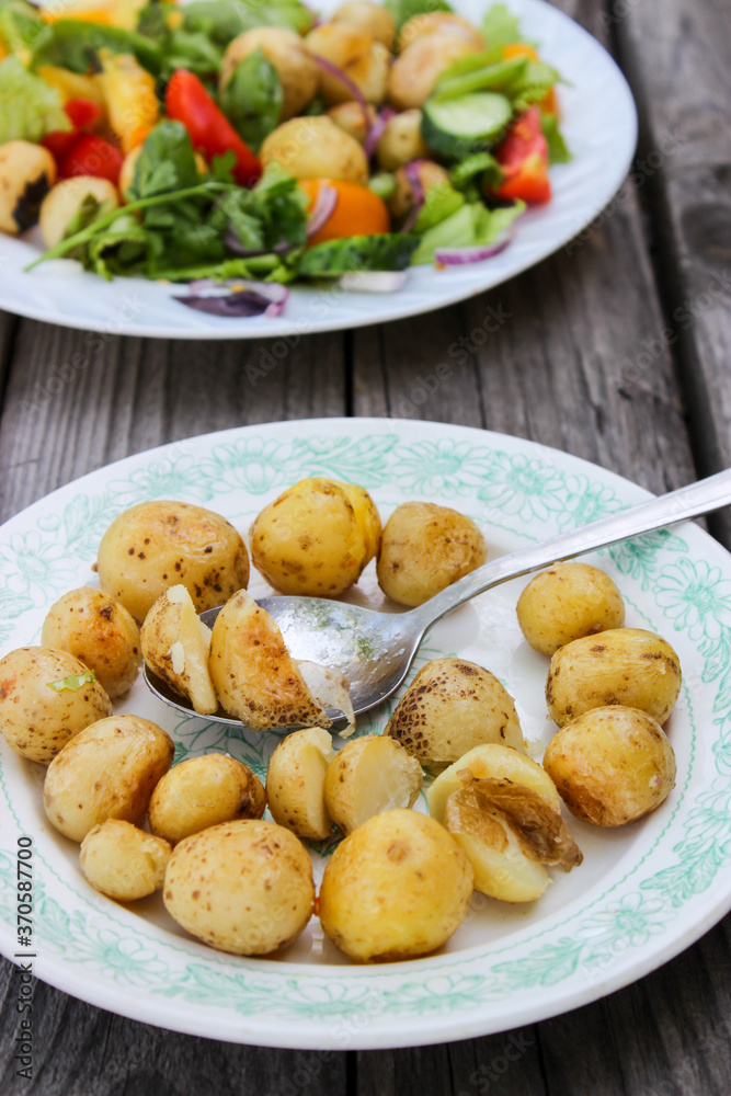 Round new potatoes fried to Golden brown with tomatoes, herbs and lettuce Round new potatoes fried to Golden brown with tomatoes, herbs and lettuce