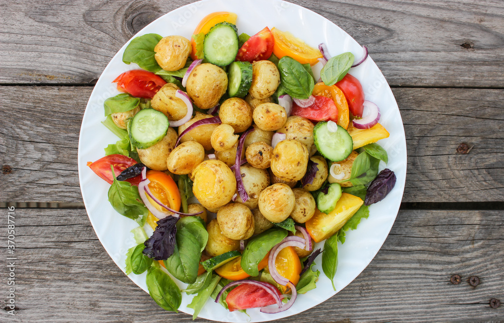Round new potatoes fried to Golden brown with tomatoes, herbs and lettuce