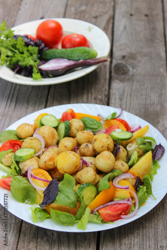 Round new potatoes fried to Golden brown with tomatoes, herbs and lettuce