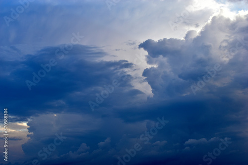 A stormy landscape with blue Cumulus clouds on the horizon.