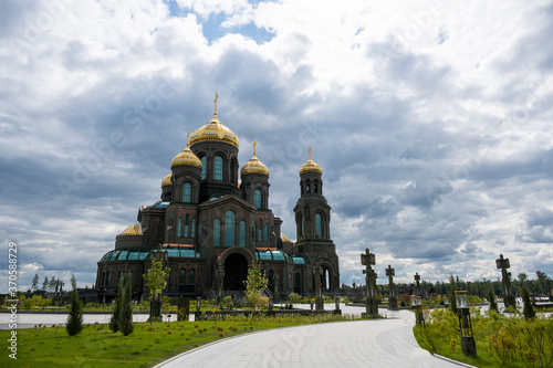 panoramic view of a dark temple with golden domes against a background of gray clouds