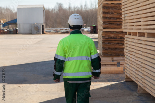 engineer next to a pile of boards at a sawmill